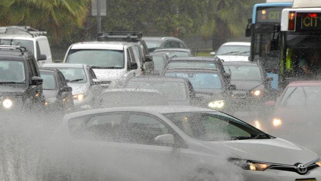 A car drives through water, caused by heavy rain, on a road in Sydney on November 28, 2018. - Flights were cancelled, railway lines closed and motorists stranded on flooded roads as a month's worth of rain fell on Sydney early on November 28, leaving emergency services battling to respond. (Photo by Peter PARKS / AFP)