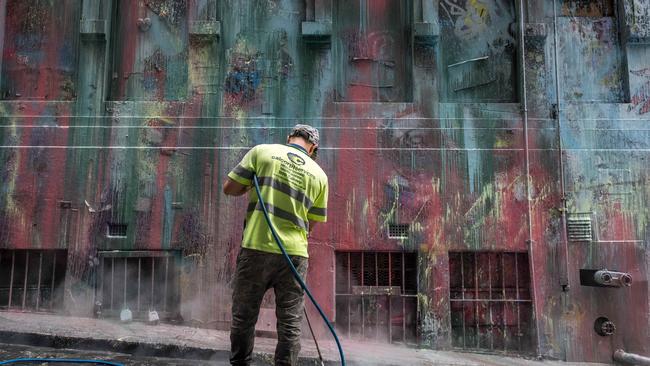 Crews pressure clean the ground after the Hosier Lane graffiti was vandalised. Picture: Jake Nowakowski