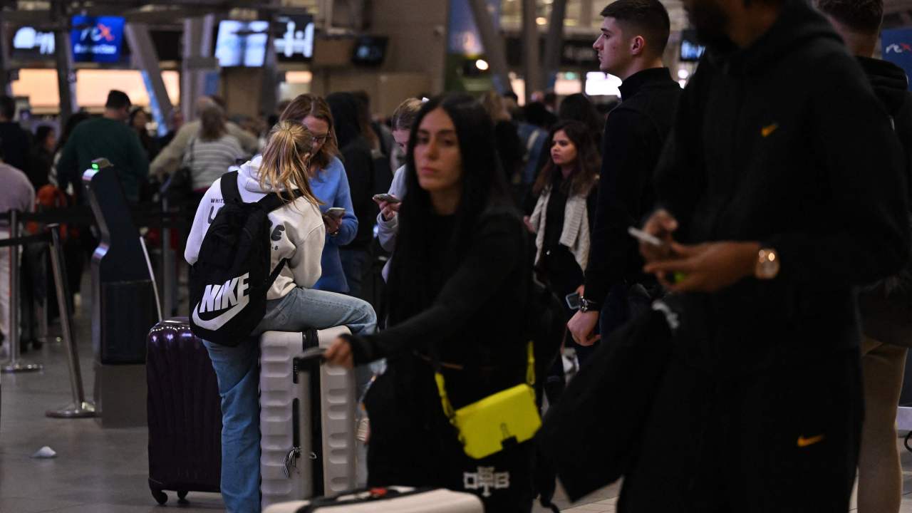 Travellers wait in long service lines at the Sydney domestic airport on July 19, 2024. A large-scale outage wrought havoc on IT systems across Australia, with the country's national broadcaster, its largest international airport, and a major telecommunications company reporting issues. (Photo by Saeed KHAN / AFP)