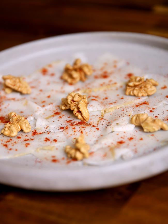 Thinly shaved lardo with walnuts and sweet paprika.