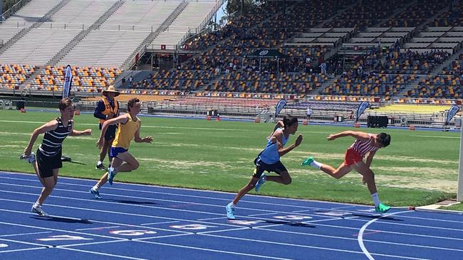 Israel Leota, far right, lunges to win the 13 years 90m hurdles at the GPS Track and Field.