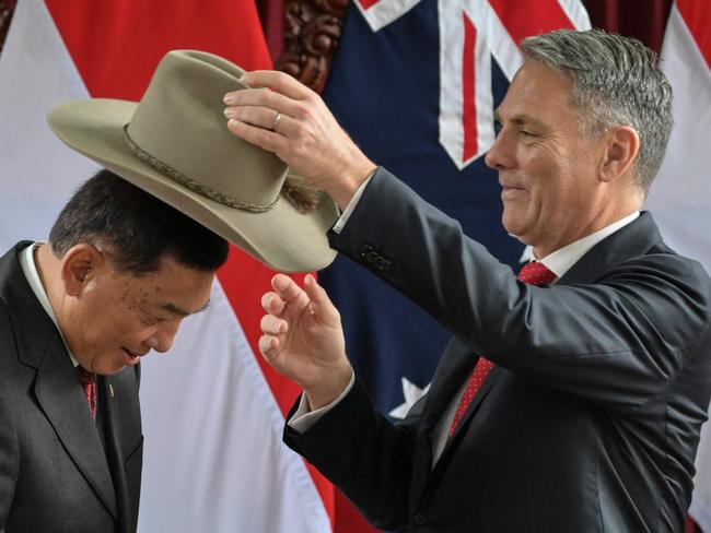 Indonesia's Defence Minister Sjafrie Sjamsoeddin (L) receives an Australian hat as a gift from Australian Deputy Prime Minister and Minister for Defence Richard Marles (R) during their meeting in Jakarta on June 5, 2025. (Photo by BAY ISMOYO / AFP)