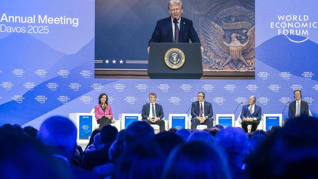 US President Donald Trump is seen on a giant screen during his address by video conference at the World Economic Forum (WEF) annual meeting in Davos on January 23, 2025. (Photo by Fabrice COFFRINI / AFP)