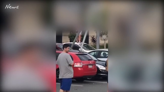 Children jump on a car at Helensvale Shopping Centre, Gold Coast