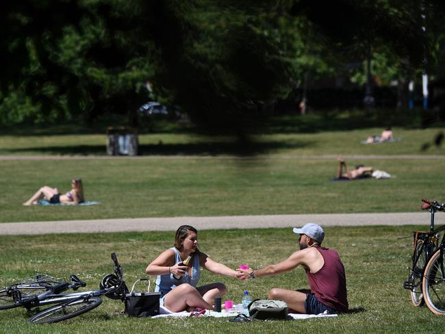 People relax in the warm weather in St James's Park in central London. Picture: AFP