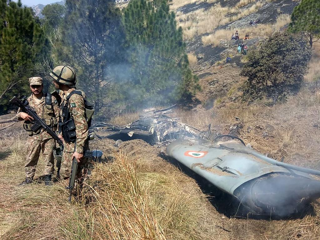 Pakistani soldiers stand next to the wreckage of an Indian fighter jet shot down in Pakistan controled Kashmir at Somani area in Bhimbar district near the Line of Contro. Picture: AFP