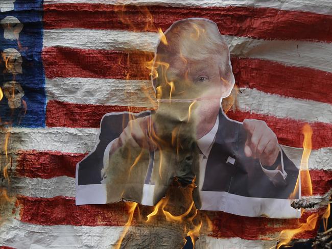 Protesters burn a picture of Mr Trump on a mock US flag outside the US Embassy in Manila, Philippines today over his anti-immigration stance. Picture: Aaron Favila/AP Photo