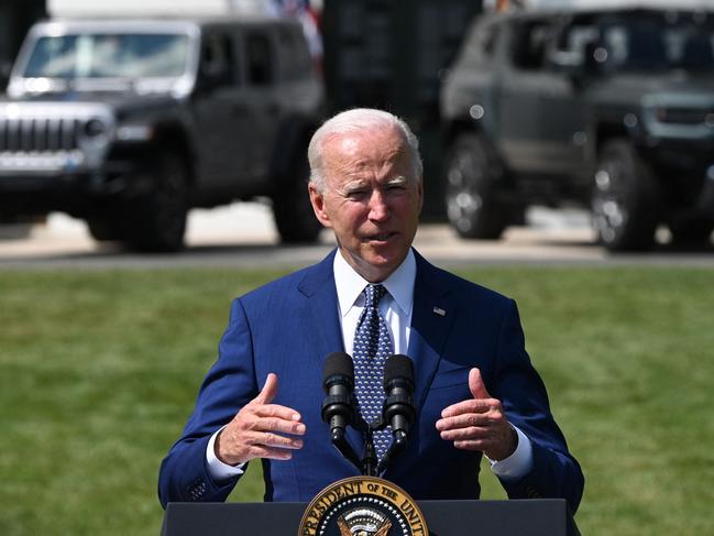 Electric vehicules are seen in the background as US President Joe Biden delivers remarks on the steps his Administration is taking to strengthen American leadership on clean cars and trucks on the South Lawn of the White House in Washington, DC, on August 5, 2021. (Photo by Jim WATSON / AFP)