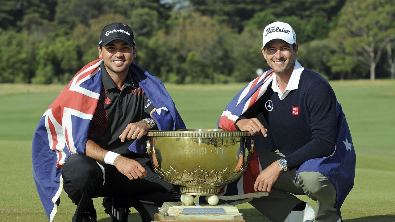 Jason Day, left of Australia and compatriot Adam Scott draped in their national flags with the World Cup of Golf trophy after winning the team event at Royal Melbourne Golf Course in Australia, Sunday, Nov. 24, 2013. (AP Photo/Andy Brownbill)