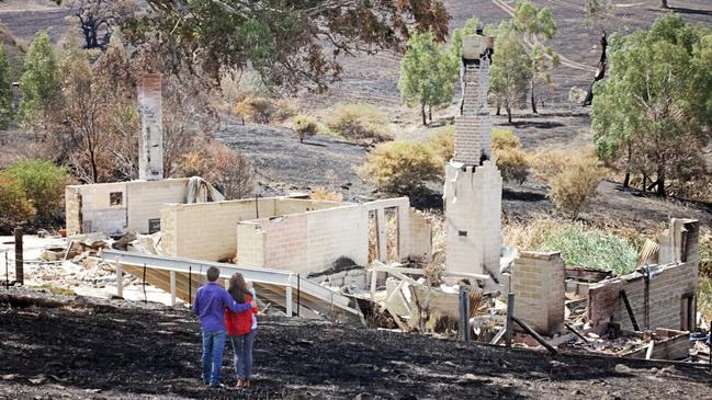 Scott Pape and wife Liz survey what was left standing after the bushfire.