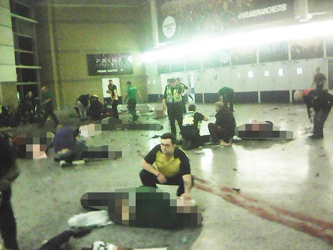 Helpers attend to people inside Manchester Arena after a suicide bomber detonated a bomb.