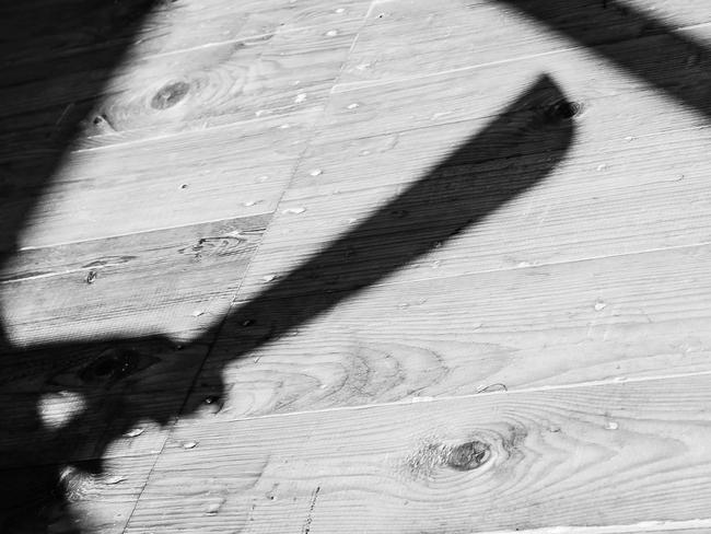 a shadow of a hand holding bid machete knife