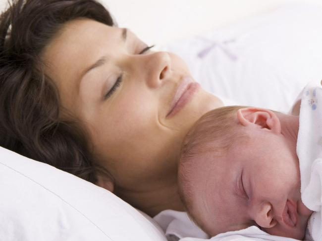 Generic of mother and baby sleeping in bed.