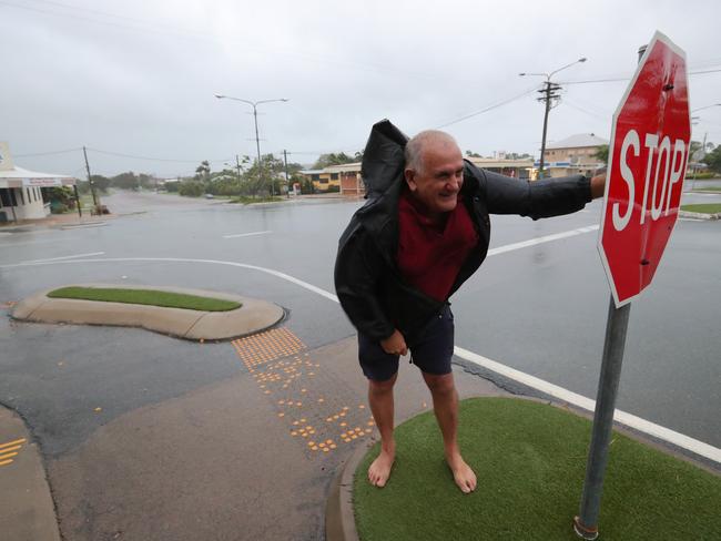 Evacuated resident Bob Morton takes a quick dash outside to check the area and look at the weather while he can just after dawn in the main street as Bowen. Picture: Lyndon Mechielsen/The Australian