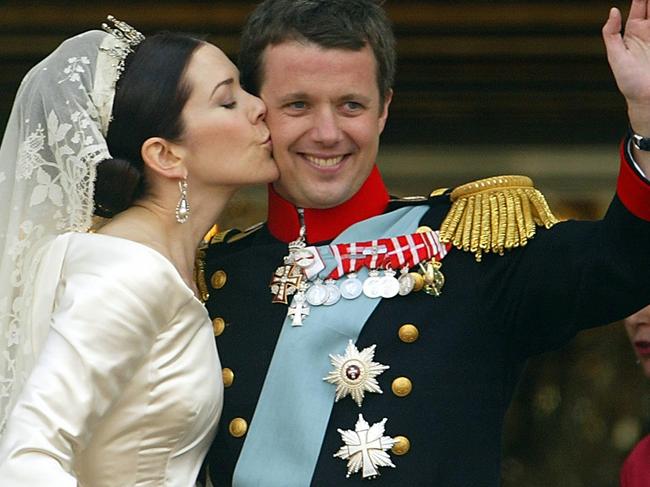 Crown princess Mary of Denmark kisses her husband Crown prince Frederik on the balcony at Amalienborg castle to the cheer of thousands in Copenhagen, 14 May 2004, after the wedding ceremony at Copenhagen cathedral. Picture:AFP