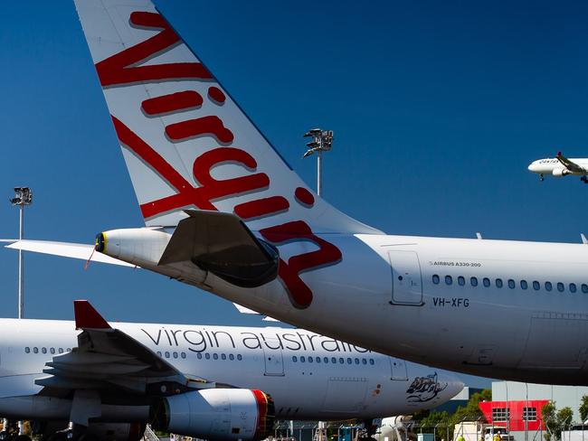 Virgin Australia aircraft are seen parked on the tarmac at Brisbane International airport on April 21, 2020. - Cash-strapped Virgin Australia collapsed on April 21, making it the largest carrier yet to buckle under the strain of the coronavirus pandemic, which has ravaged the global airline industry. (Photo by Patrick HAMILTON / AFP)