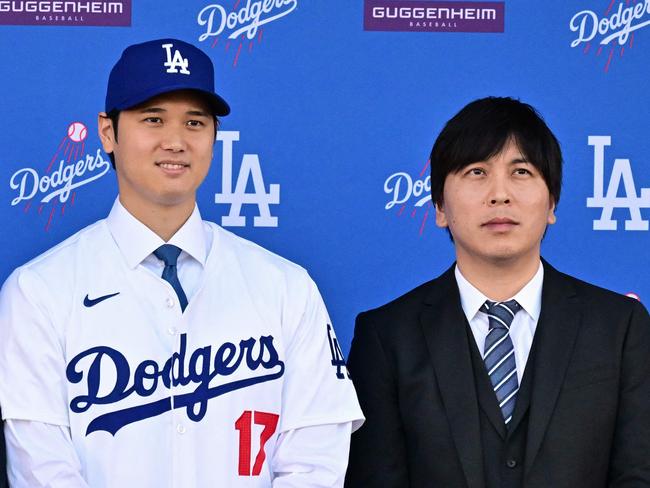 (FILES) Japanese baseball player Shohei Ohtani (C) poses with his agent Nez Balelo (L) and Japanese interpreter Ippei Mizuhara during a press conference on his presentation after signing a ten-year deal with the Los Angeles Dodgers at Dodgers Stadium in Los Angeles, California on December 14, 2023. Representatives of Shohei Ohtani said March 20, 2024 the baseball superstar had been the victim of "a massive theft," reported to involve millions of dollars allegedly stolen by the Japanese ace's interpreter to place bets with a suspected illegal bookmaker. The Los Angeles Times reported that the firm had looked into the actions of Ohtani's longtime interpreter Ippei Mizuhara after the newspaper learned that Ohtani's name had surfaced in a federal investigation of alleged illegal bookmaker Mathew Bowyer. (Photo by Frederic J. Brown / AFP)