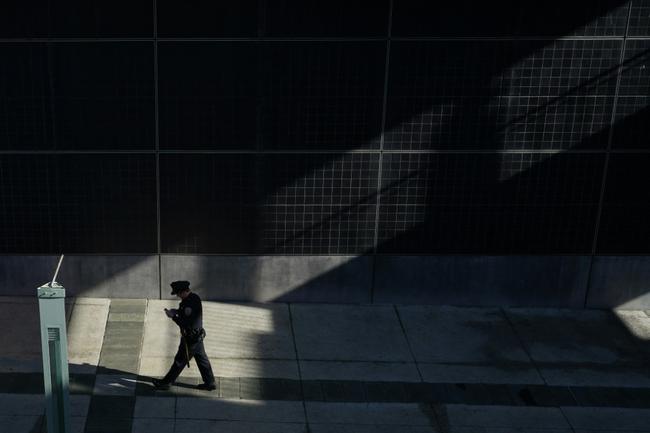 A police officer walks near APEC Summit headquarters in San Francisco as the city took pains to clean up ahead of the arrival of world leaders