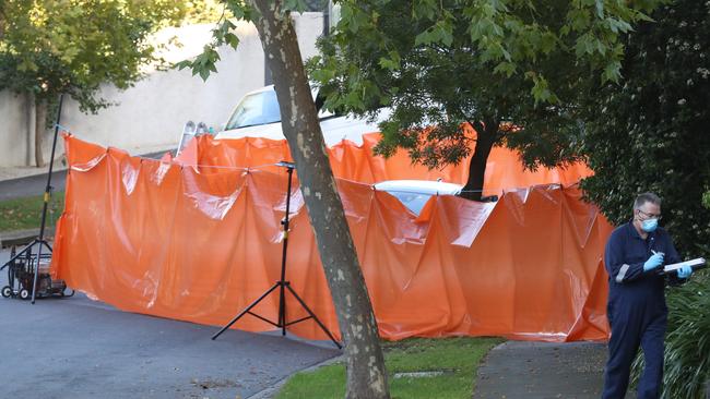 A massive orange tarp placed around the car where two women were stabbed. Picture: David Crosling