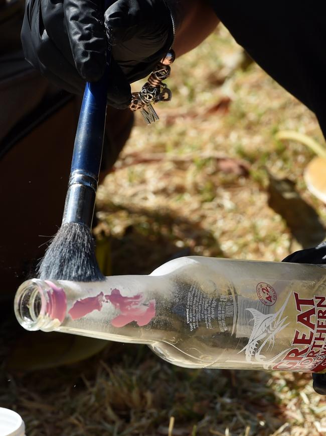 Police dust a beer bottle for finger prints in St Kilda. Picture: Nicole Garmston