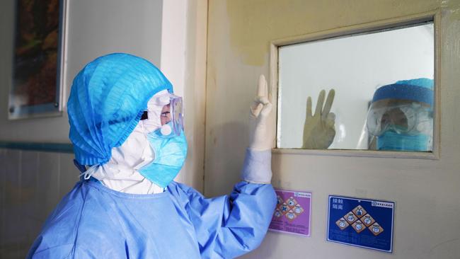 Medical staff gesturing to each other in an isolation ward. Picture: STR/AFP