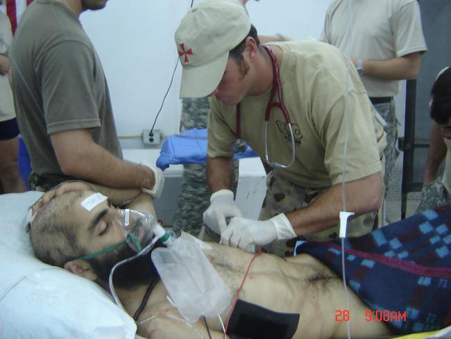 Medic Brad Watts works on a wounded patient in the field hospital at Tarin Kowt