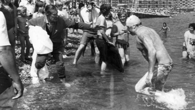 Marathon swimmer swimming coach Des Renford leaving water at Dover after swimming the English Channel.