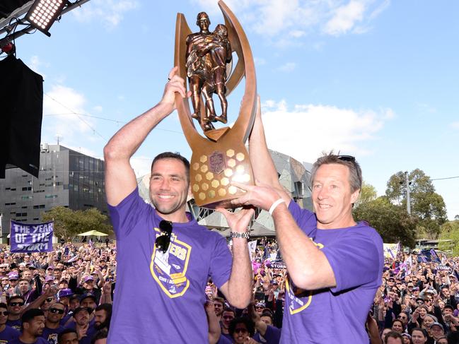 Storm Captain Cameron Smith and coach Craig Bellamy hold up the AFL Premiership Grand Final Trophy during a welcome home ceremony at Federation Square in Melbourne, Monday, October 2, 2017. Melbourne Storm won the NRL Premiership against the Cowboys on Sunday. (AAP Image/Mal Fairclough) NO ARCHIVING