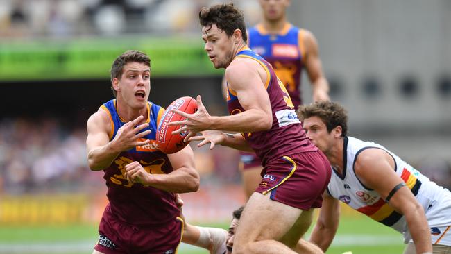 Jarrod Berry (left) of the Lions handballs to Lachie Neale. Picture: AAP Image/Darren England