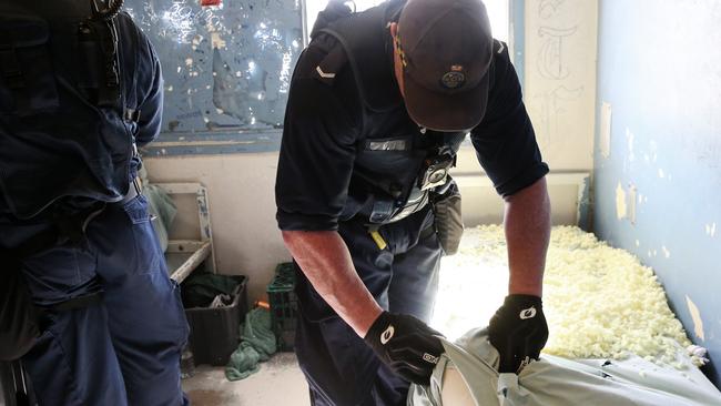 Officers search a cell. Picture: Richard Dobson