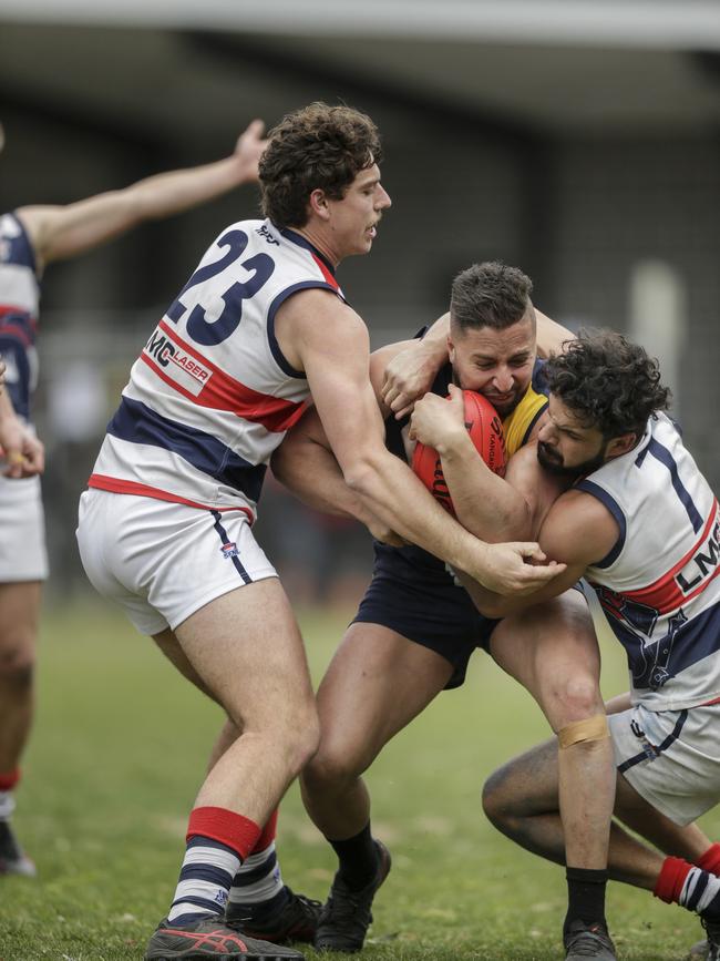 Enayte Samadi (Doveton) tackled by Highett players Mitch Hoar and Pat Singh. Picture: Valeriu Campan