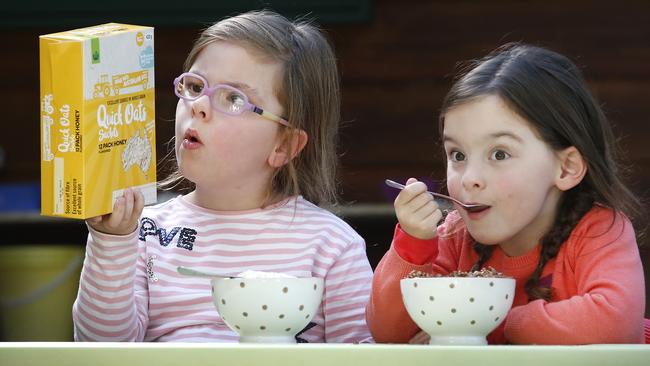 Twins Eloise and Zoe, 5, tuck into their favourite breakfast cereal. Picture: David Caird