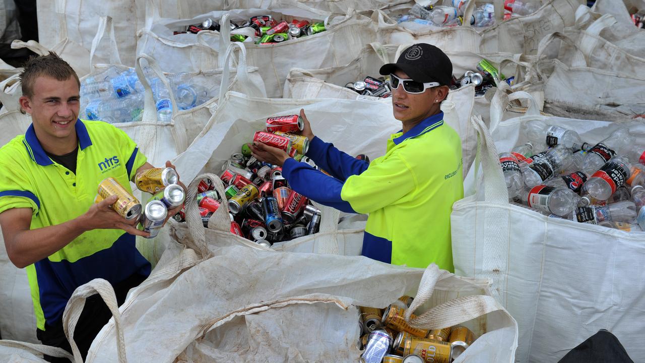 Workers Alex Jenkins from Karama and Matt Brennan from Darwin sorting bottles and cans at the Shoal Bay Waste Disposal centre.