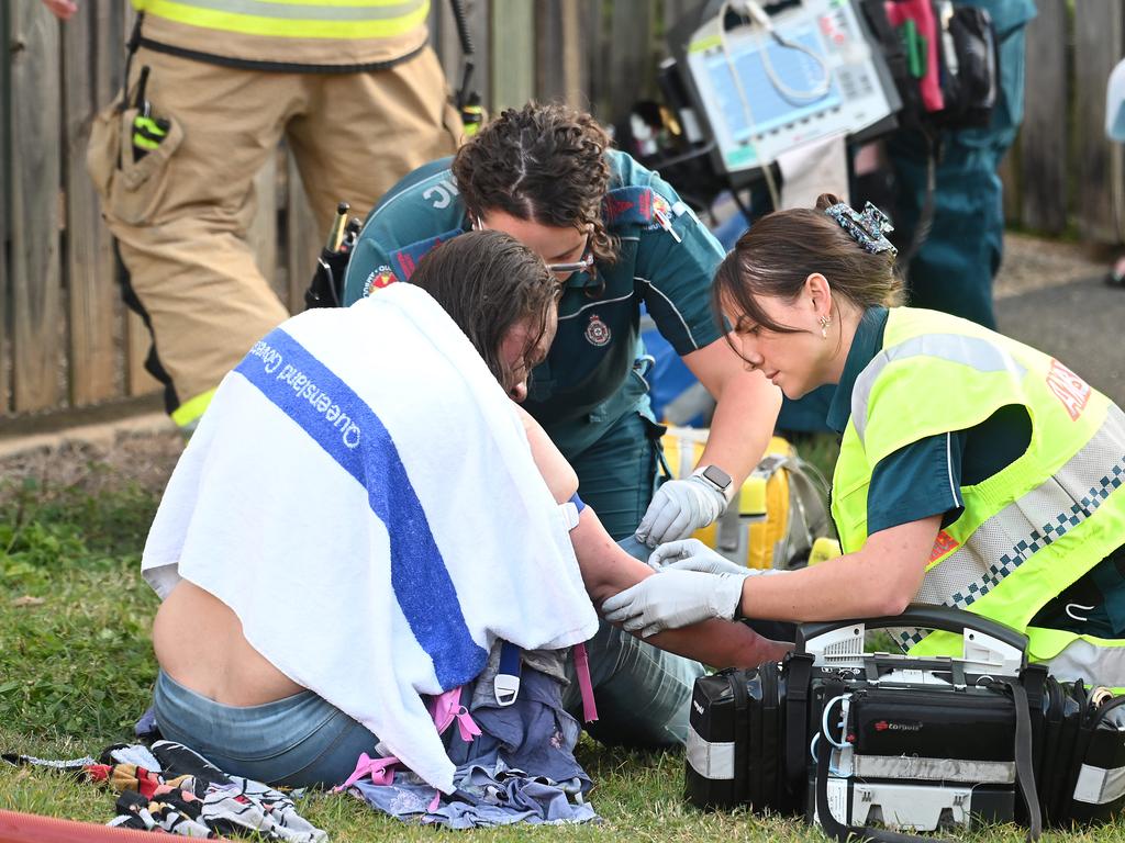 Emergency services treating a person after at a house fire in Amelia Street, Albion. Picture: John Gass