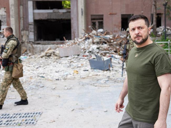 Ukrainian President Volodymyr Zelenskyy walking past a partially destroyed building during his visit to the position of Ukrainian troops in Mykolaiv region. Picture: AFP