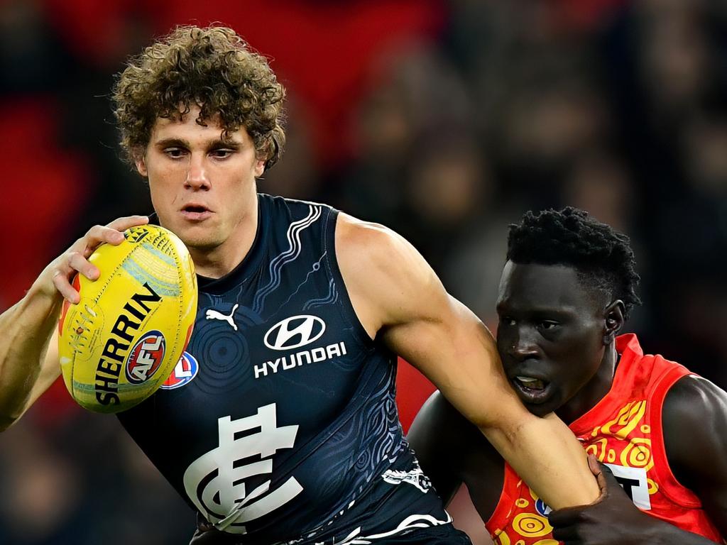 MELBOURNE, AUSTRALIA – MAY 25: Charlie Curnow of the Blues kicks whilst being tackled by Mac Andrew of the Suns during the round 11 AFL match between Carlton Blues and Gold Coast Suns at Marvel Stadium, on May 25, 2024, in Melbourne, Australia. (Photo by Josh Chadwick/AFL Photos/via Getty Images)