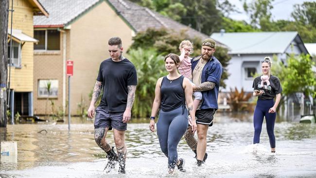 Thursday 31st March 2022 Lismore Suburbs: Corey Hazelton 25 chef at bank cafe Amber Velluti, registered nurse at Lismore Base Hospital Shianne Burgess 26 work at autobarn, Matt Daniels hold his step-daughter Maia burgess 6yrs Walking through the flood waters after trying to access Main Street. Picture: Darren Leigh Roberts