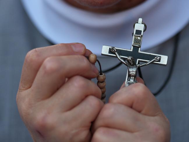 CORRECTED VERSION: VATICAN CITY, VATICAN - APRIL 22: A nun holds a crucifix during Rosary prayers in honour of Pope Francis at St Peter's Square on April 22, 2025 in Vatican City, Vatican. The Vatican announced that Pope Francis died at 88, on Monday at 07:35 local time (05:35 GMT) and 