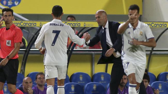 Real Madrid's Cristiano Ronaldo, center, shakes hands with Real Madrid's head coach Zinedine Zidane.