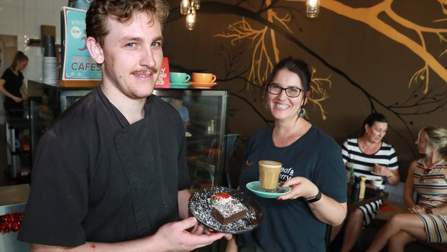 Butternut Café business partners Lisa Cruickshank and Mark Mills hold cafe favourites, a butternut brownie with cream and an almond latte. (AAP IMAGE / Angelo Velardo)