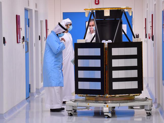 Engineers observe a KhalifaSat model at the Mohammed Bin Rashid Space Centre (MBRSC), in the Gulf city of Dubai on July 5, 2020. - The oil-rich United Arab Emirates has built a nuclear power programme and sent a man to space, and now plans to join another elite club by sending a probe to Mars. Only the United States, India, the former Soviet Union, and the European Space Agency have successfully sent missions to orbit the Red Planet, while China is preparing to launch its first Mars rover later this month. The UAE, a collection of sheikhdoms better known for its skyscrapers, palm-shaped islands and mega attractions, is now pushing to join their ranks in what will be a first for the Arab world. (Photo by GIUSEPPE CACACE / AFP)