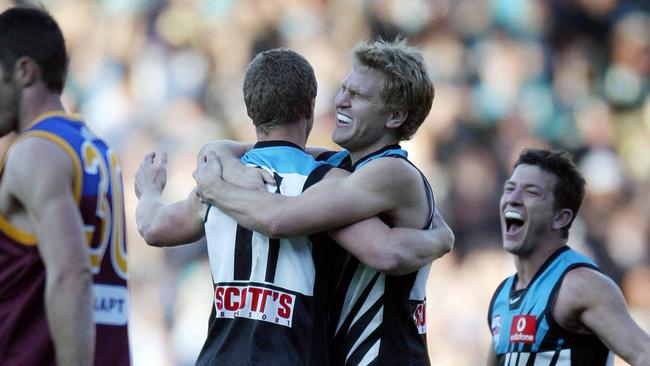 Kane Cornes and Hardwick hug on the siren after winning the 2004 premiership.