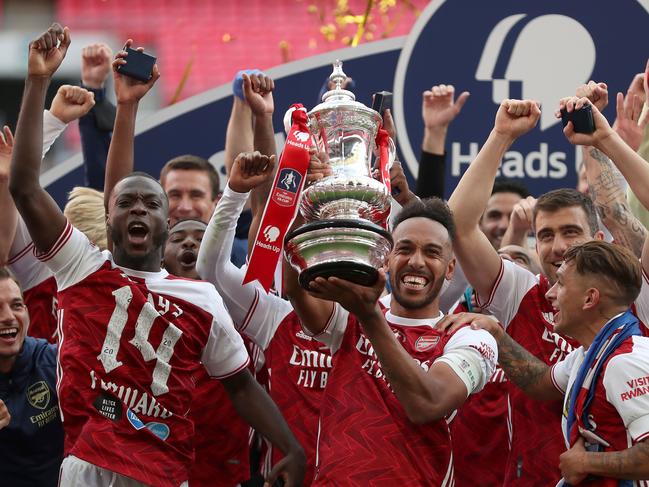 Arsenal's Gabonese striker Pierre-Emerick Aubameyang holds the winner's trophy as the team celebrates victory after the English FA Cup final football match between Arsenal and Chelsea at Wembley Stadium in London, on August 1, 2020. - Arsenal won the match 2-1. (Photo by Catherine Ivill / POOL / AFP) / NOT FOR MARKETING OR ADVERTISING USE / RESTRICTED TO EDITORIAL USE