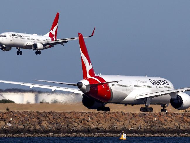 This photo taken on September 4, 2024 shows a Qantas Airways Boeing 737-800 plane coming in to land next to a Qantas Airways Boeing 787 Dreamliner aircraft preparing to take-off at Sydney International Airport. (Photo by DAVID GRAY / AFP)