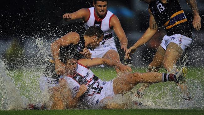 Young Saint Tom Ledger slides for the ball at a waterlogged Wangaratta.