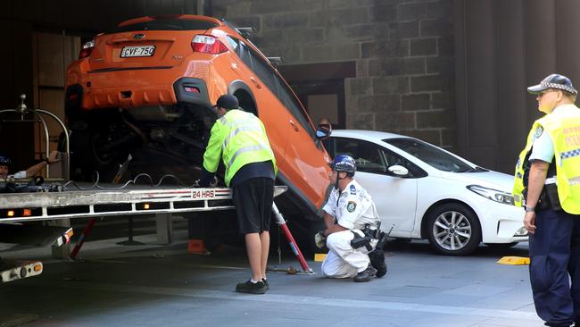 The orange Subaru is towed away. Picture: John Grainger