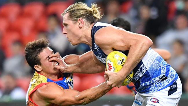 Mark Blicavs (right) of the Cats palms off Suns captain David Swallow (left). Picture: AAP Image/Darren England).