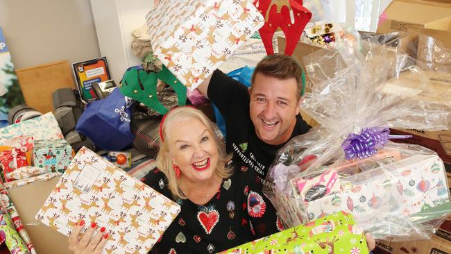 Susie Longman and Cam Christie, at Sam O'Connor's office in Labrador, sorting through donated goodies for the annual Gold Coast Community Christmas lunch. Picture: Glenn Hampson