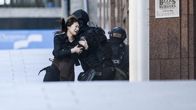 Jieun Bae is taken into the arms of a member of the NSW Police tactical Operations Unit after she fled the Lindt cafe in Martin Place, Sydney.