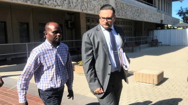 John Mugambi Mwamba walks out of the Townsville courthouse with his lawyer Photo: Jacob Miley